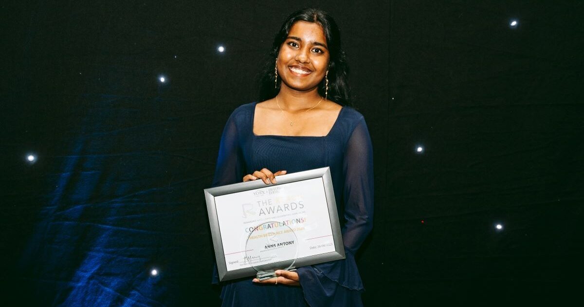 Two students smile at eachother as they work FS English