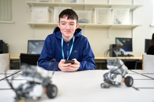 Computing Games Design Level 2 student working with two robots