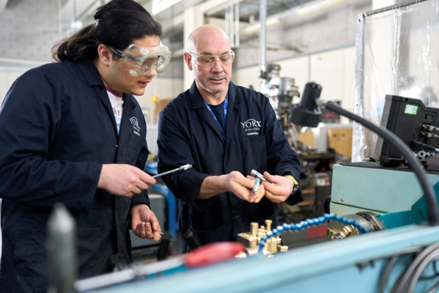 Engineering tutor and student working on the fabrication machinery