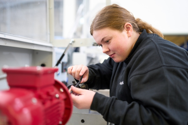 Engineering apprentice working on a machine