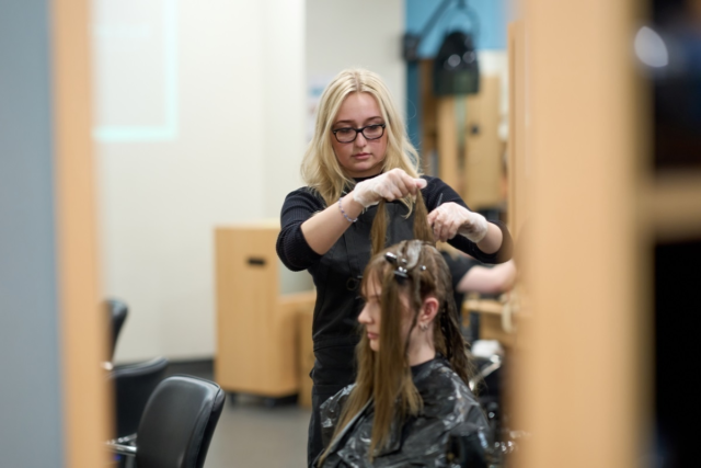 Hairdressing student colouring a clients hair